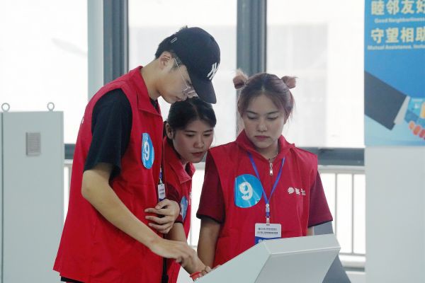 4.在2023中国—东盟智慧物流国际邀请赛现场，三名参赛选手正在共同研究讨论如何操作指示台，他们正努力克服语言障碍完成比赛.jpg